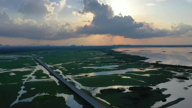 鸟瞰图多彩的戏剧性天空与阳光和云在日落草地和沼泽。视频下载