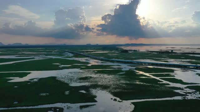 鸟瞰图多彩的戏剧性天空与阳光和云在日落草地和沼泽。视频下载