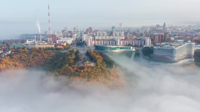 空中鸟瞰萨拉瓦特·尤拉耶夫纪念碑与国会大厅，电视塔，森林和城市建筑在雾中。视频素材