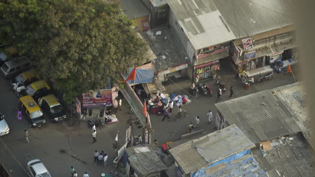 高海拔的汽车，摩托车和行人徘徊在街道上的小商店-孟买，印度视频素材