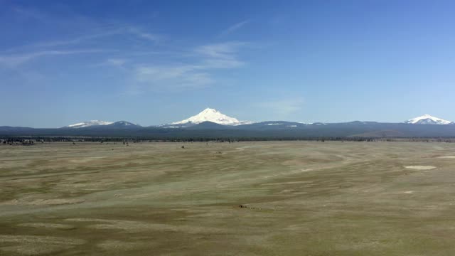 空中飞盘:在阳光明媚的日子里，长草平原延伸到蓝色的山麓和白雪覆盖的山脉-俄勒冈州波特兰视频素材