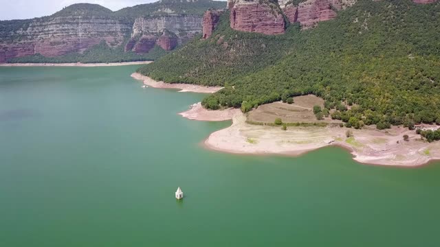 航拍向前:西班牙鲁皮特山附近Sau水库的教堂塔视频素材