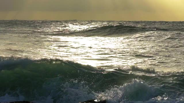 慢镜头平移:海浪在海洋对多云的天空在日落-卧龙岗，澳大利亚视频素材