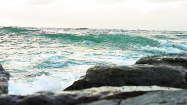 慢镜头倾斜:海浪拍打在岩石在海洋-卧龙岗，澳大利亚视频素材