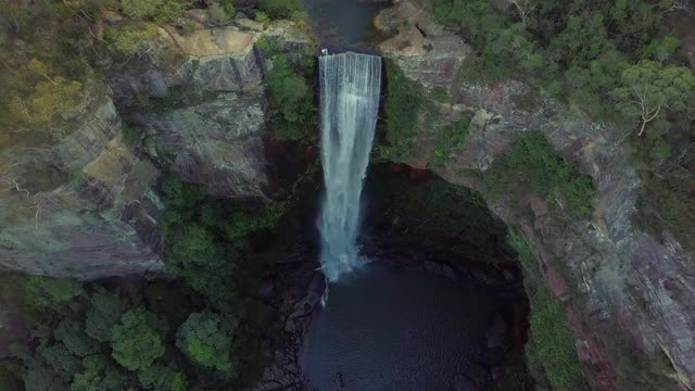 空中攀登:瀑布从岩石悬崖在森林植物-贝尔莫瀑布，澳大利亚视频素材