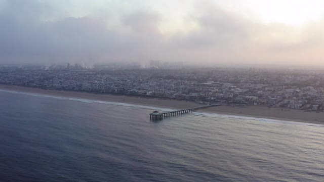 空中淘金:日出时对着天空的沿海城市和海洋-曼哈顿海滩，加利福尼亚视频素材