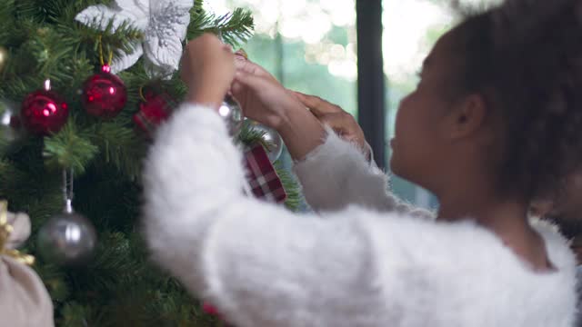 快乐的非洲女孩孩子与父亲装饰圣诞节，快乐的家庭和圣诞场景的概念视频素材