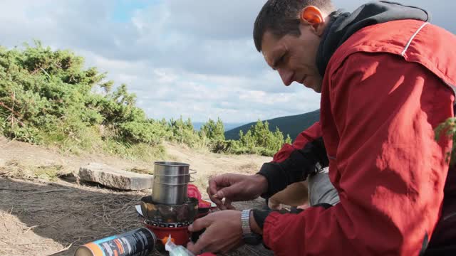 游客在山里，在煤气炉上泡茶。单独旅行视频素材