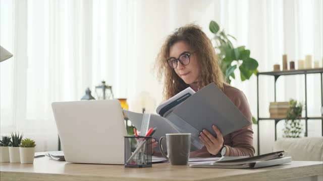 用笔记本电脑分析文件的女人视频素材