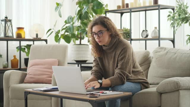 在家里用笔记本电脑分析文件的女人视频素材