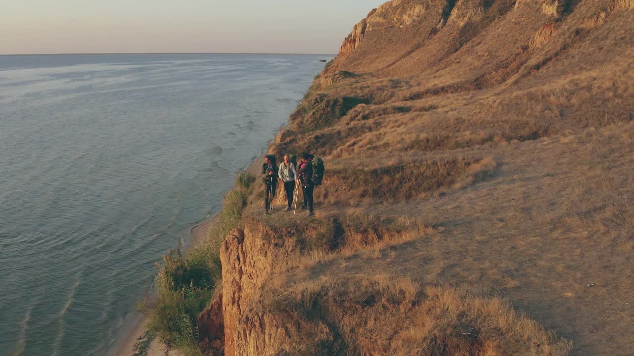 旅行者们背着背包站在海边的沙滩上视频素材