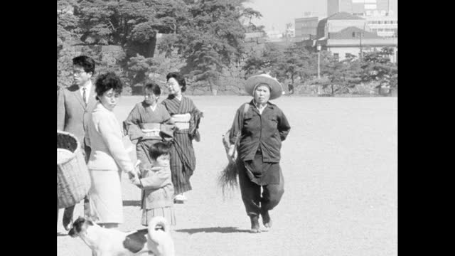 在东京，公园管理员在游客周围捡拾垃圾;1964视频素材