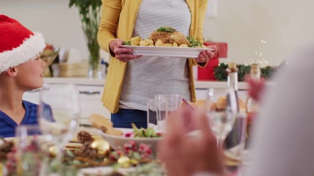 戴着圣诞帽的白人妇女给全家人送食物视频素材