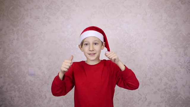 戴着红色圣诞帽的男孩祝福新年和圣诞节快乐视频素材