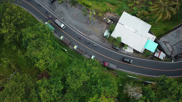 无人机拍摄的巴厘岛绿色稻田俯视图，道路上的汽车和运动模糊视频素材