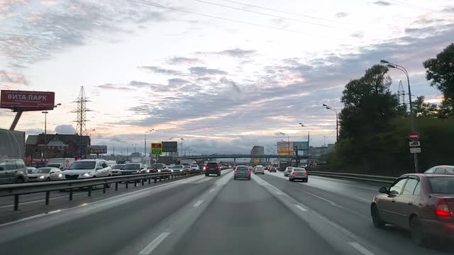 俄罗斯。透过挡风玻璃观看一辆汽车在一个有交叉路口的八车道道路上行驶，汽车在这条道路上行驶，迎面的车道上已经形成了交通堵塞视频素材