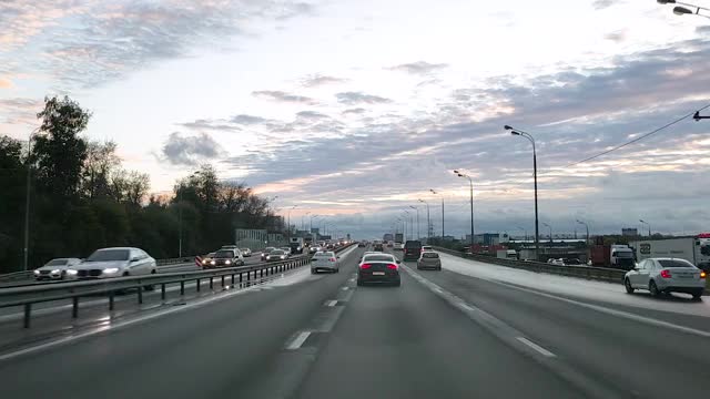 俄罗斯。透过挡风玻璃观看一辆汽车在一个有交叉路口的八车道道路上行驶，汽车在这条道路上行驶，迎面的车道上已经形成了交通堵塞视频素材