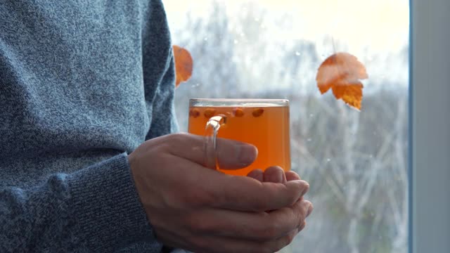 特写男手捧一杯沙棘茶。视频素材