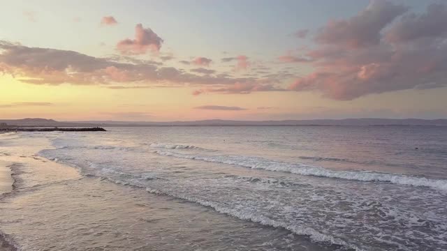 鸟瞰图的海面与蓝色的海浪下日落的天空。视频素材