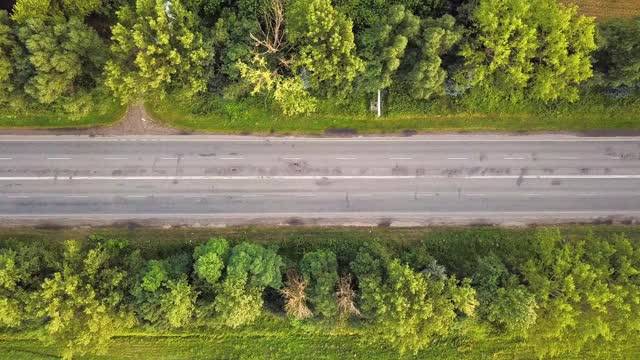 绿树间行驶车辆的道路鸟瞰图。视频素材