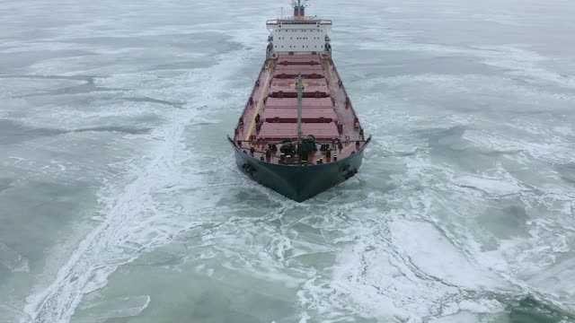 空中的史诗巨大的钢船破冰的船头船和漂浮在大浮冰。在冻结的航道中维持航行。自航专用船红船。视频素材