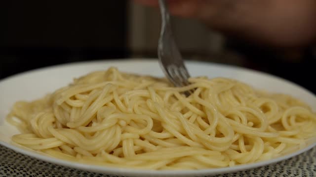 一盘意大利面，一个男人在吃叉子，特写视频素材