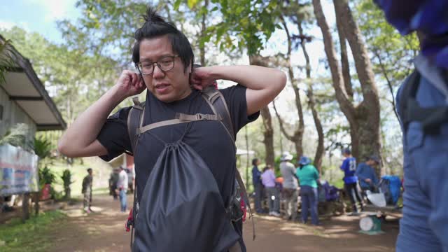 男性徒步初学者在他的装备上得到了当地公会的帮助视频素材