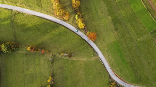 鸟瞰图上的汽车行驶在乡村道路在秋天视频素材