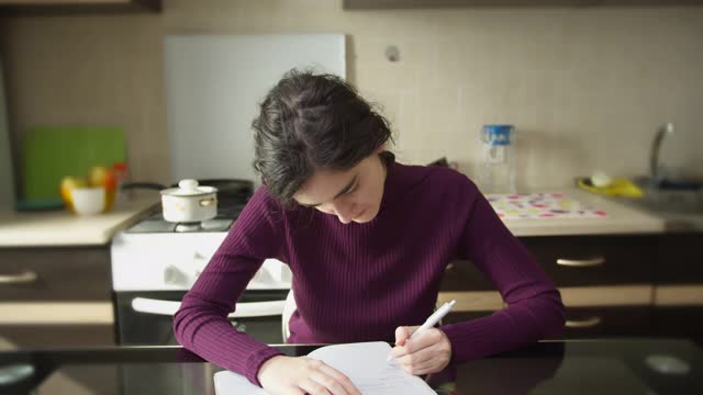 女生在笔记本上写字，左撇子，在家学习视频素材