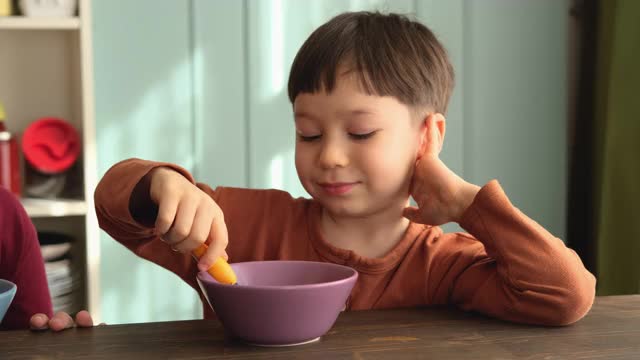 可爱的孩子们早餐吃玉米片和牛奶。视频素材