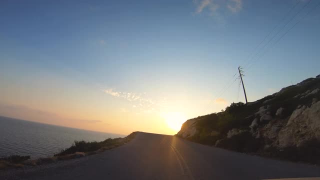 在日落时，希腊赞特海边的全景道路上行驶的摄像车前波夫视频素材