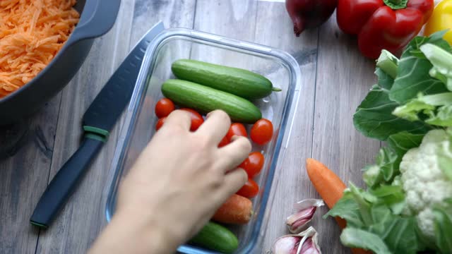 女人用手从装着蔬菜的塑料容器里摘西红柿视频素材