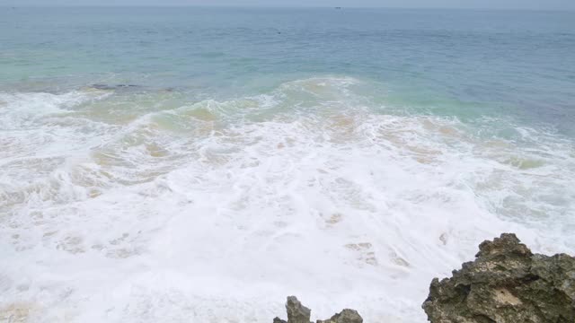 观看热带岛屿的海洋海滩与巨大的海浪从岩石与地平线视频素材