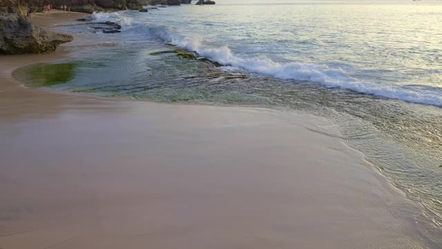 热带海滩与大波浪和悬崖在日落与人视频素材