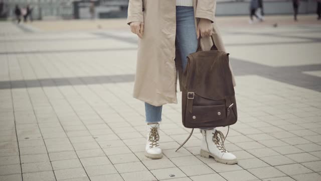 陌生的时尚的年轻女子站在城市广场上背包。女白人游客在城市街道上等待向导。旅游及旅游概念视频素材