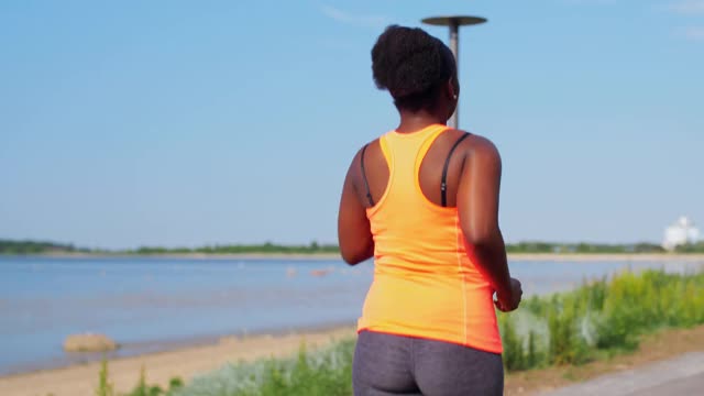 年轻的非裔美国女人在海边跑步视频素材