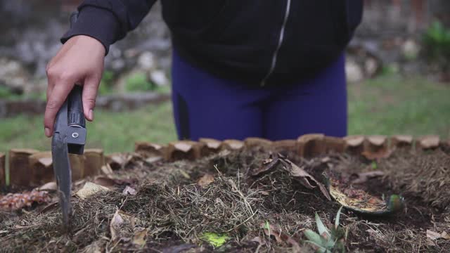 亚洲女性用花园泥铲堆肥视频素材