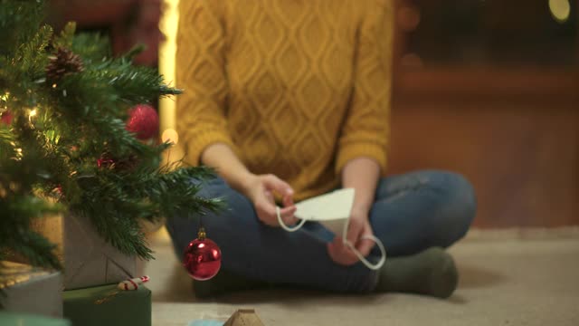 一名年轻女子在圣诞树上戴面具视频素材