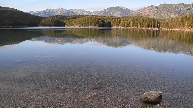 在日落时反射的山湖。日落时分在巴伐利亚阿尔卑斯的Eibsee。视频下载