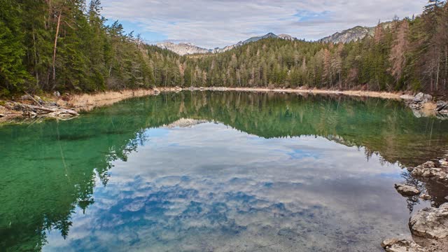 在德国阿尔卑斯山的一个反射山湖的时间流逝。德国巴伐利亚Eibsee上空移动云的时间流逝。视频下载