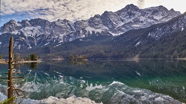 时间流逝的一个反射山湖与雪山的背景。德国巴伐利亚州祖格斯匹兹前面的Eibsee的时间流逝。视频下载