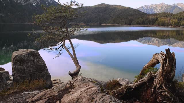 在日落时反射的山湖。日落时分在巴伐利亚阿尔卑斯的Eibsee。视频下载