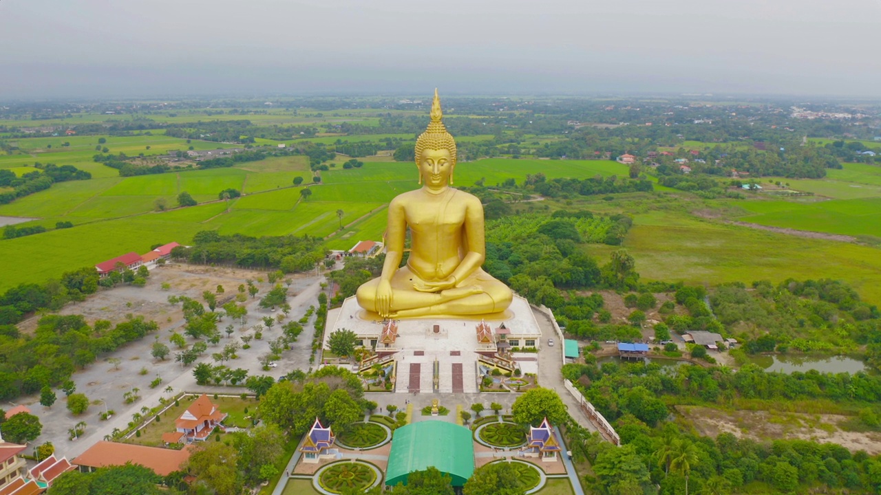 俯瞰曼谷昂通区芒昂寺的巨大金佛，周围是稻田。泰国的一个城市。视频素材