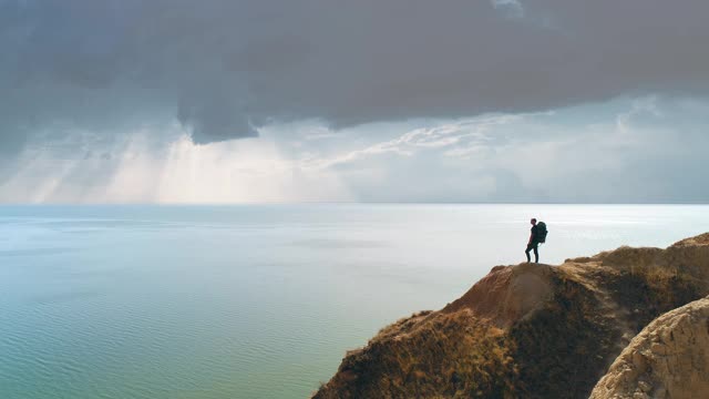 游客站在山崖上，背景是海景视频素材