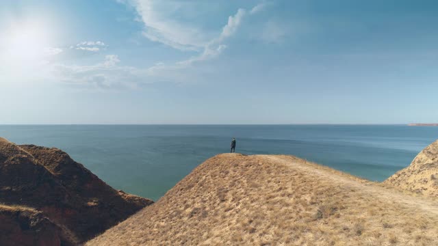 旅行者站在山顶，欣赏美丽的海景视频素材