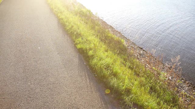 俯视图两名跑步者在阳光明媚的日子沿着河边跑步视频素材