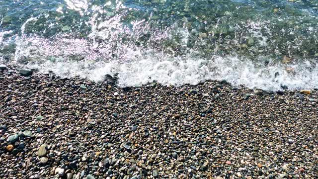 海景。小波浪拍打着布满卵石的海滩。视频素材