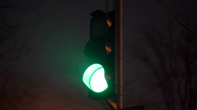 绿色交通灯在夜晚城市街道特写。视频素材