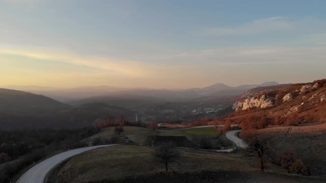 航拍一架无人机从山-通过山的道路，山的岩石景观视频素材