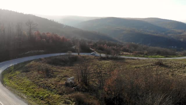 航拍一架无人机从山-通过山的道路，山的岩石景观视频素材